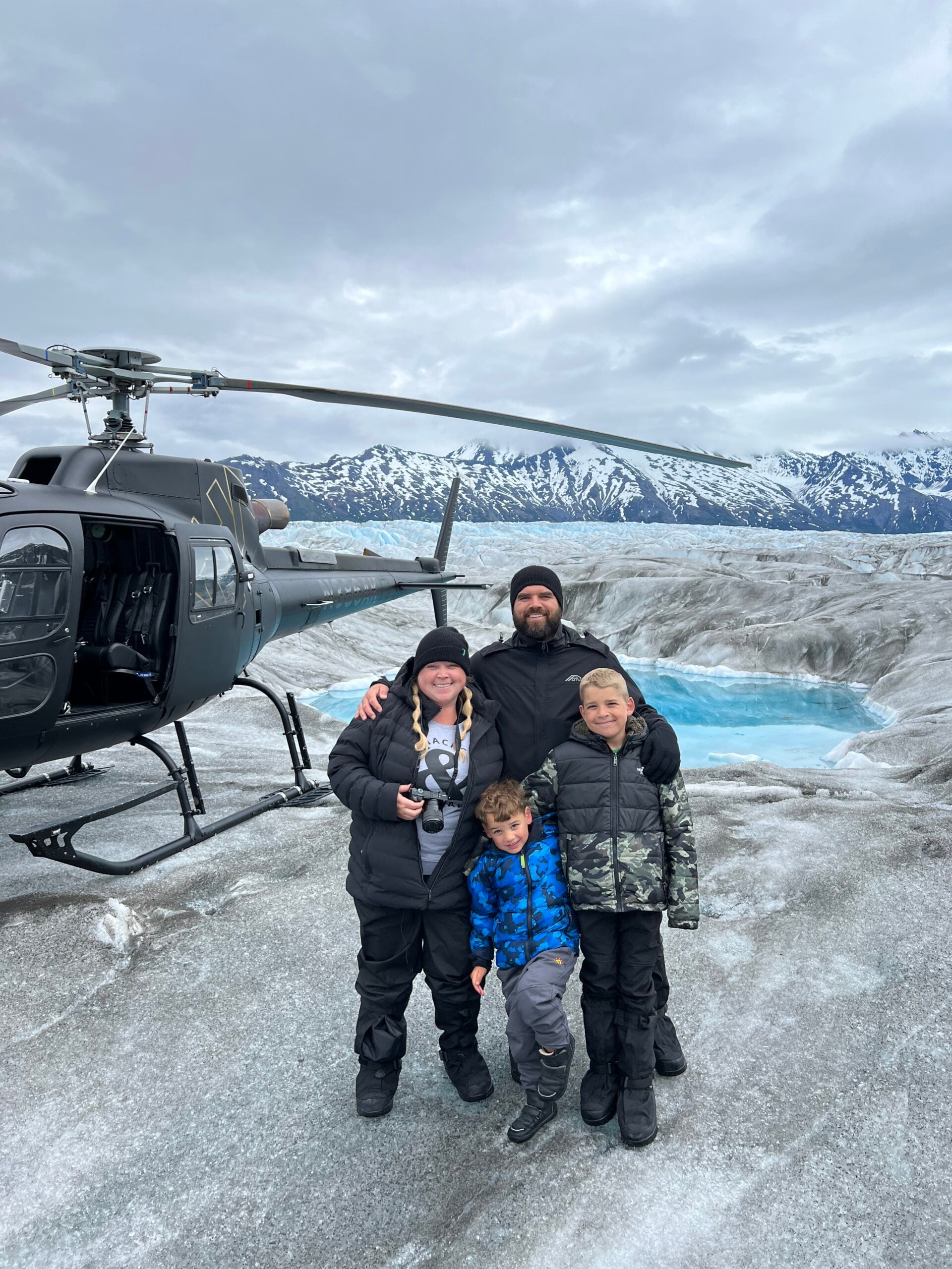 A family vacation trip to Alaska. My family on a glacier with a helicopter beside us.
